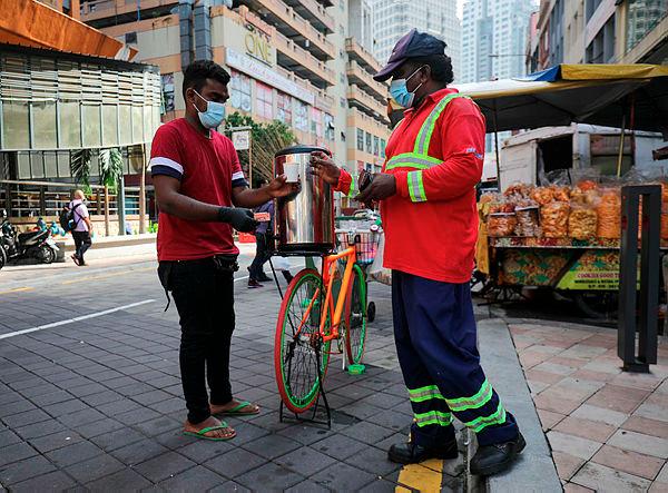 $!TEA ON WHEELS ... A ‘teh halia’ vendor selling the beverage from his bicycle in Jalan Masjid India, Kuala Lumpur yesterday. – ASYRAF RASID/THESUN