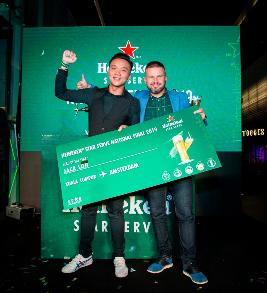 Vasily Baranov, Sales Director of Heineken Malaysia Berhad (R) presenting Jack Loh, winner of Heineken Star Serve National Final 2019, the mock ticket to a trip to Amsterdam.