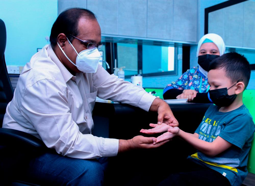 BUKIT MERTAJAM, 18 MAY-Penang KPJ Specialist Hospital Pediatrician, Dr Abdul Nasir Mohamed examined a child infected with Hand, Foot and Mouth Disease (HFMD), today. MASRY CHE ANI/THESUN