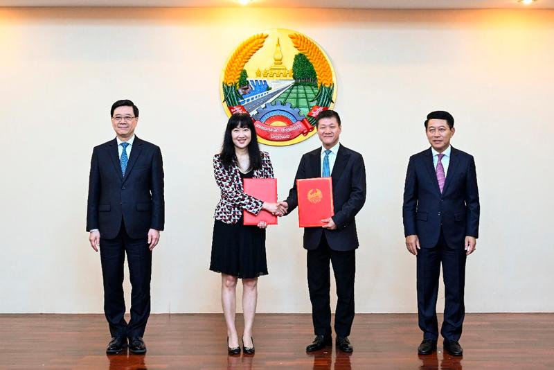 $!Mr Lee (first left) and Laos Deputy Prime Minister and Foreign Affairs Minister Saleumxay Kommasith (first right) witness the exchange of memoranda of understanding by organisations and enterprises of Hong Kong and Laos.
