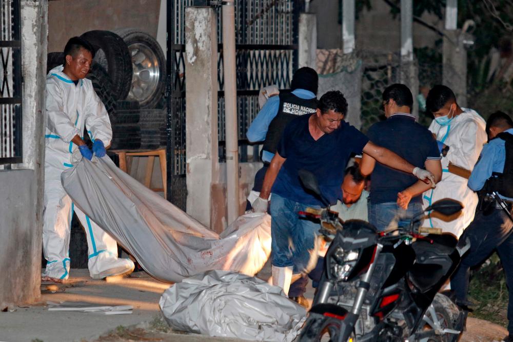 Forensic personnel remove the body of one of the eleven people killed in a pool hall in Choloma, about 180 km north of Tegucigalpa, early on June 25, 2023. AFPPIX