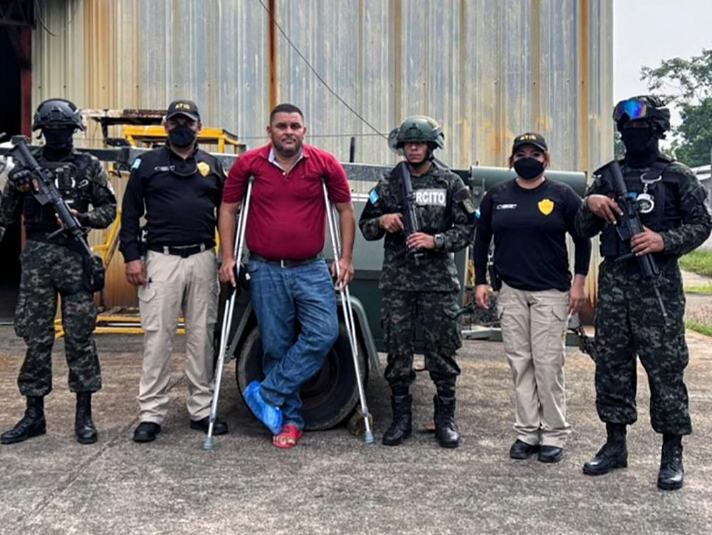 This handout picture released by Honduras' Technical Bureau for Criminal Investigation (ATIC) shows the mayor of Brus Laguna municipality, Gracias a Dios department, Wilmer Manolo Wood (3rd-L), being guarded by members of ATIC and the Military Police of Public Order (PMOP) after being captured in La Ceiba, Honduras, on August 27, 2023. AFPPIX