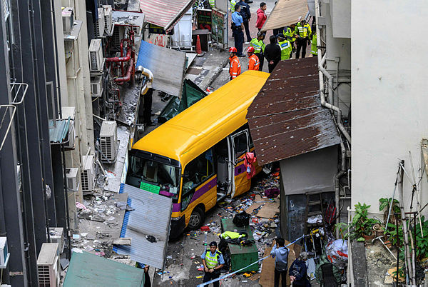 Police investigate after an empty schoolbus crashed in the North Point district of Hong Kong on Dec 10, 2018. — AFP