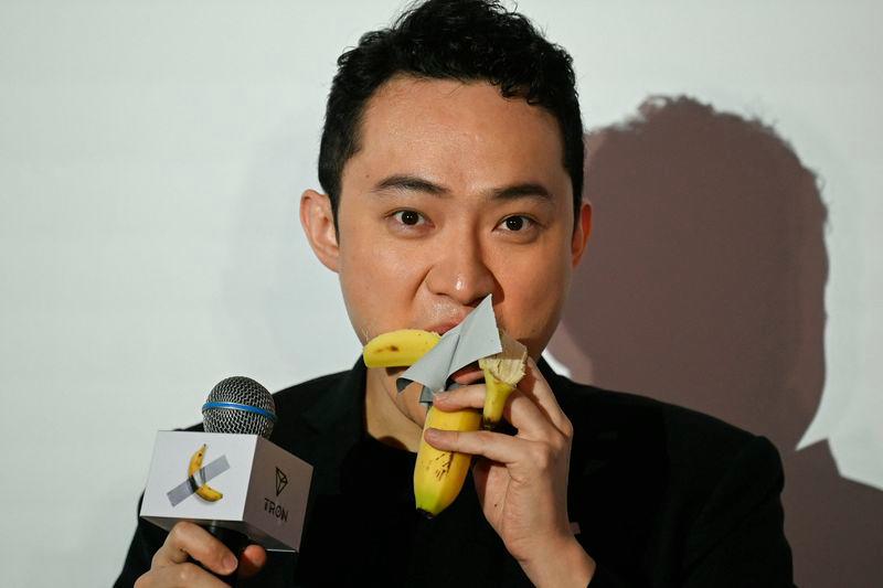 Chinese-born crypto founder Justin Sun eats a banana artwork composed of a fresh banana stuck to a wall with duct tape, in Hong Kong on November 29, 2024, after buying the provocative work of conceptual art by Italian artist Maurizio Cattelan at a New York auction for $6.2 million. - AFPPIX