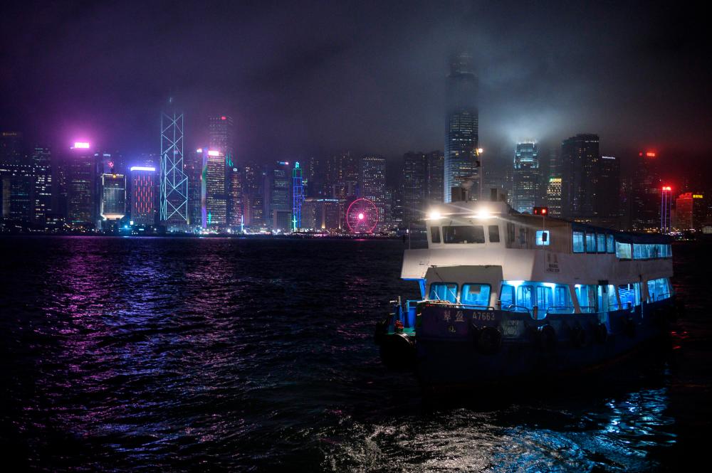 A boat sails as a general view of Victoria Harbour is seen in Hong Kong on February 14, 2020. - AFP