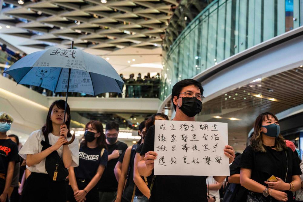 Pro-democracy protesters demonstrate in a shopping mall in the district of Yuen Long to mark the two-month anniversary of the triad attack that took place in the Yuen Long train station, in Hong Kong on Sept 21, 2019. - AFP