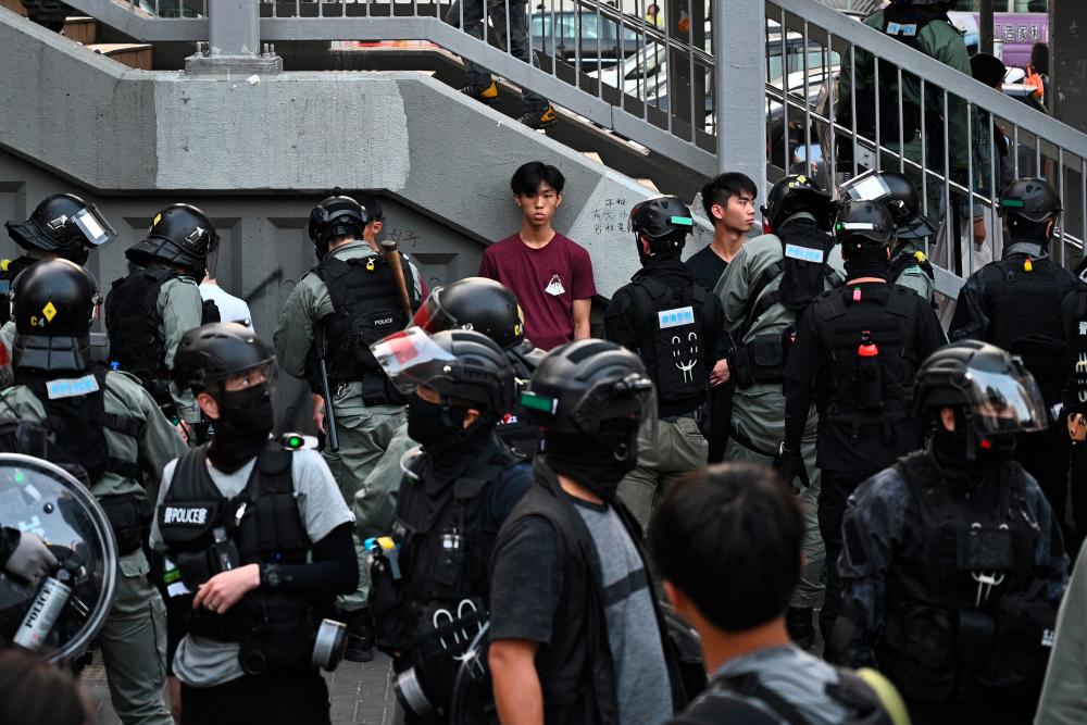 Police detain people outside a wet market during a protest in Tuen Mun district of Hong Kong on November 10, 2019. - AFP