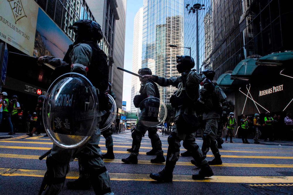 Police look for pro-democracy protesters along a road during a protest in Central in Hong Kong on November 12, 2019. - AFP
