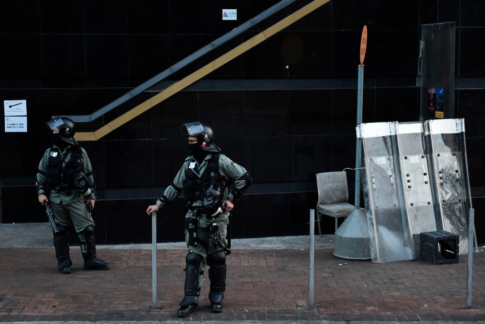 Police keep watch outside the campus of the Hong Kong Polytechnic University where dozens of pro-democracy protesters remain holed up inside, in the Hung Hom district of Hong Kong on November 21, 2019. - AFP