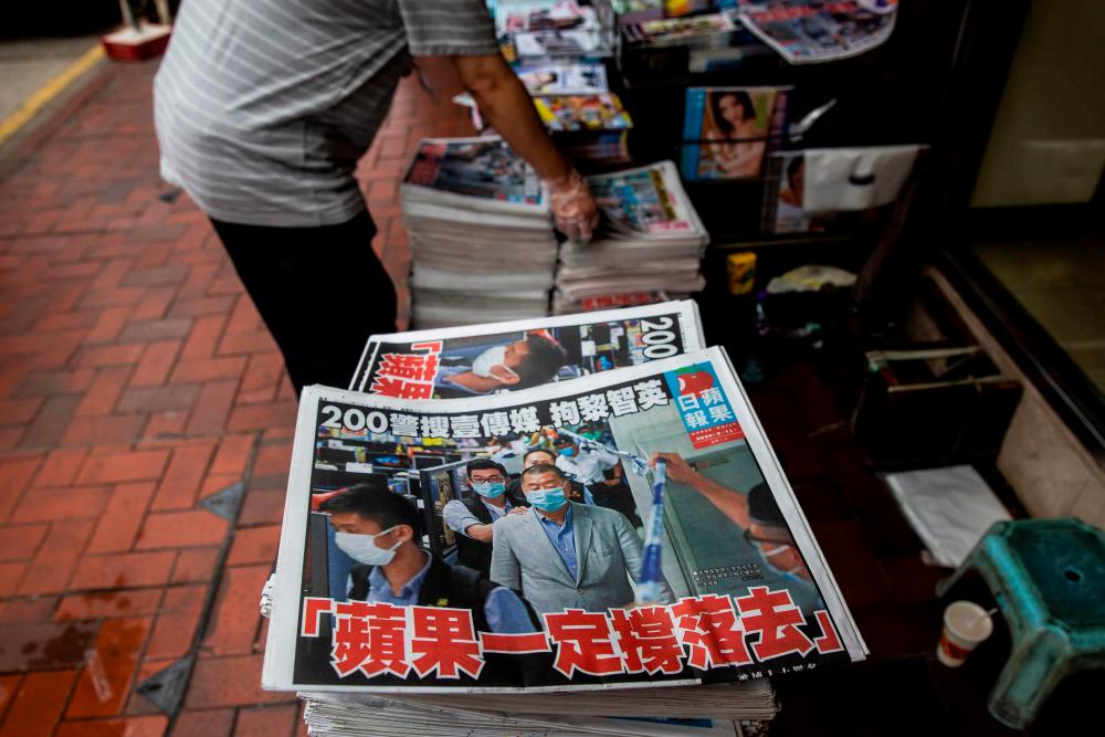 A newsstand sells copies of the Apple Daily newspaper (bottom) in Hong Kong on August 11, 2020, a day after authorities conducted a search of the newspaper’s headquarters after the company’s founder Jimmy Lai was arrested under the new national security law. — AFP