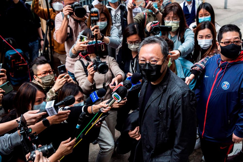 Hong Kong law professor and pro-democracy activist Benny Tai (C) speaks to the press outside Ma On Shan police station in Hong Kong on February 28, 2021, where he and 46 other dissidents were each charged with one count of “conspiracy to commit subversion” under the city’s new national security law. - AFP