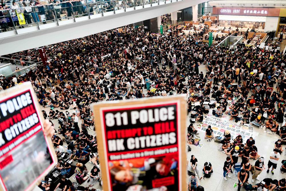 Pro-democracy protesters gather against the police brutality and the controversial extradition bill at Hong Kong's international airport on Aug 12, 2019. — AFP