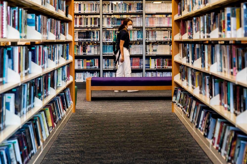A women looks at books in a public library in Hong Kong on July 4, 2020. Books written by prominent Hong Kong democracy activists have started to disappear from the city's libraries, online records show, days after Beijing imposed a draconian national security law on the finance hub. — AFP