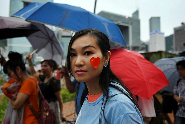 A pro-Beijing supporter displays a sticker with the China national flag on her face as she takes part in a pro-government rally at Tamar Park in Hong Kong on Aug 17.
