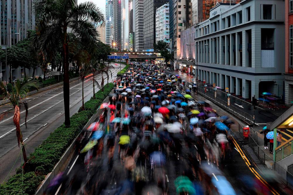 Protesters walk along a street during a rally in Hong Kong on August 18, 2019, in the latest opposition to a planned extradition law that has since morphed into a wider call for democratic rights in the semi-autonomous city. — AFP