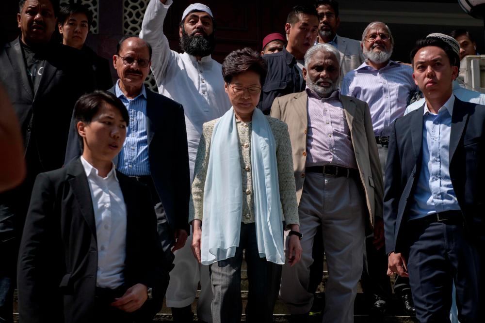 Hong Kong's Chief Executive Carrie Lam (C) exits the Kowloon Mosque, or Kowloon Masjid and Islamic Centre, in the Tsim Sha Tsui district in Hong Kong on Oct 21, 2019. — AFP