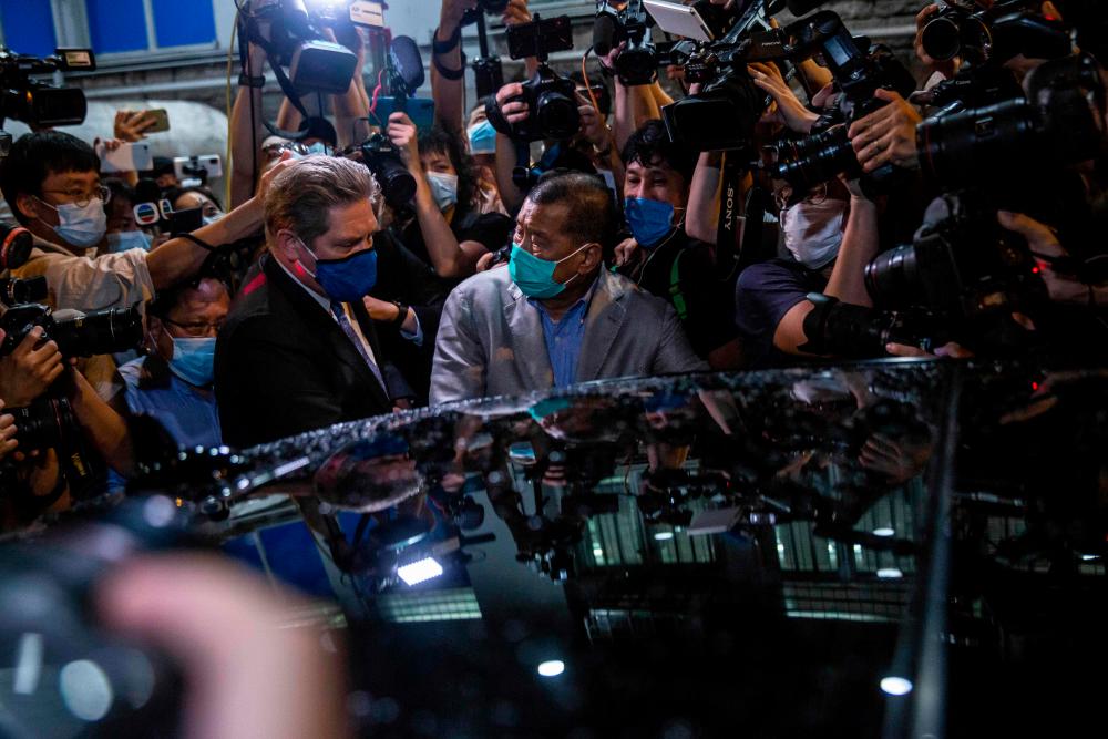 Hong Kong pro-democracy media mogul Jimmy Lai (C) pushes through a media pack to get to a waiting vehicle after being released on bail from the Mong Kok police station in the early morning in Hong Kong on August 12, 2020, after the Apple Daily founder was arrested under the new national security law. — AFP