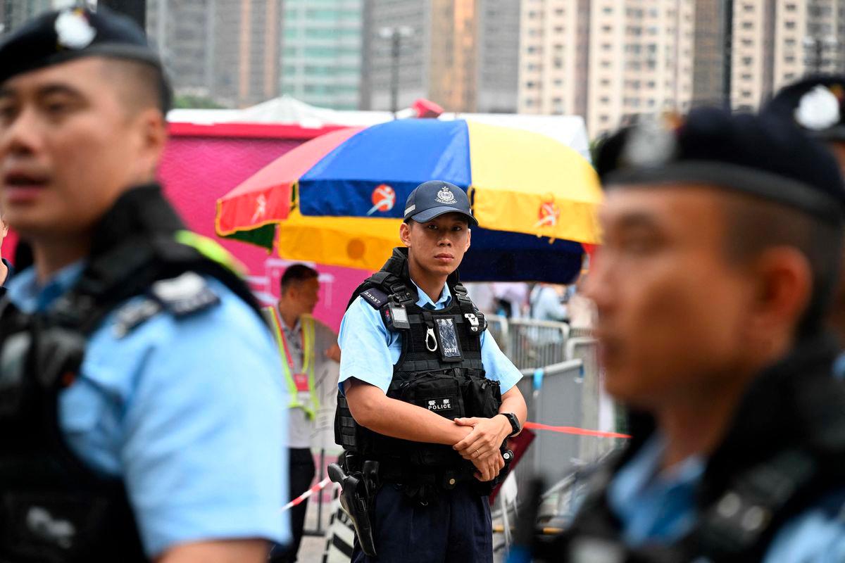 Police patrol outside a fair being held at Victoria Park in Hong Kong’s Causeway Bay district on June 4, 2025, where people traditionally gathered annually on June 4 to mourn the victims of China’s Tiananmen Square crackdown in 1989 - now banned following a national security law imposed on the city in 2020. (Photo by Peter PARKS / AFP)