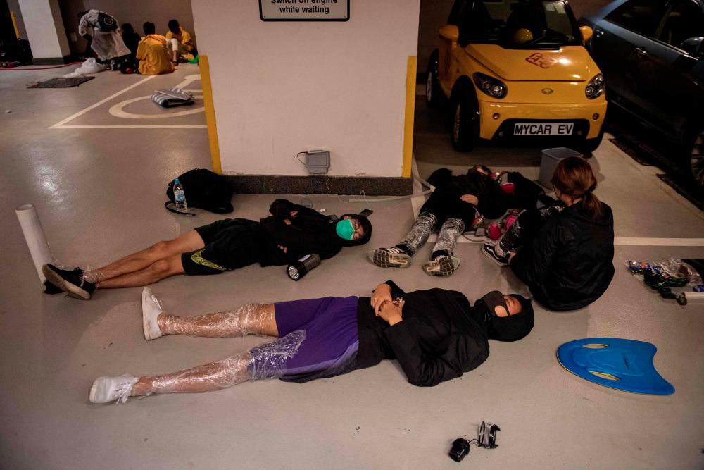 Protesters sleep on the floor of a parking lot inside the Hong Kong Polytechnic University in the Hung Hom district of Hong Kong on Nov 20. — AFP