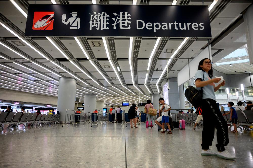 A passenger walks at the departure hall of Hong Kong’s West Kowloon Terminus, which connects the city to mainland China by rail, on August 20, 2019. — AFP