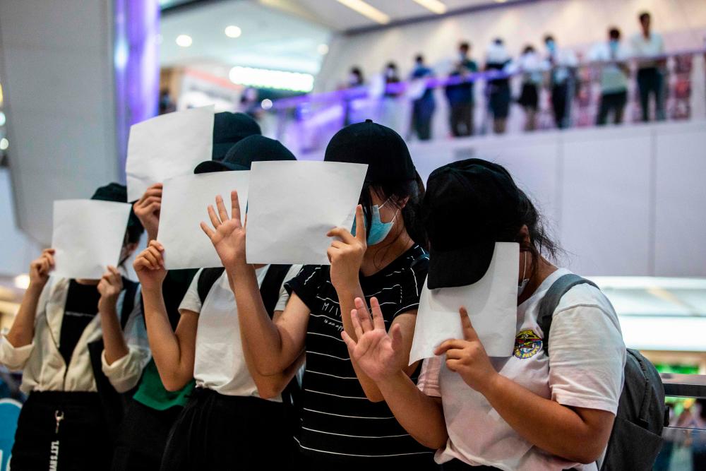 Protesters hold up blank papers during a demonstration in a mall in Hong Kong on July 6, 2020, in response to a new national security law introduced in the city which makes political views, slogans and signs advocating Hong Kong’s independence or liberation illegal. Hong Kongers are finding creative ways to voice dissent after Beijing blanketed the city in a new security law and police began making arrests for people displaying now forbidden political slogans. — AFP