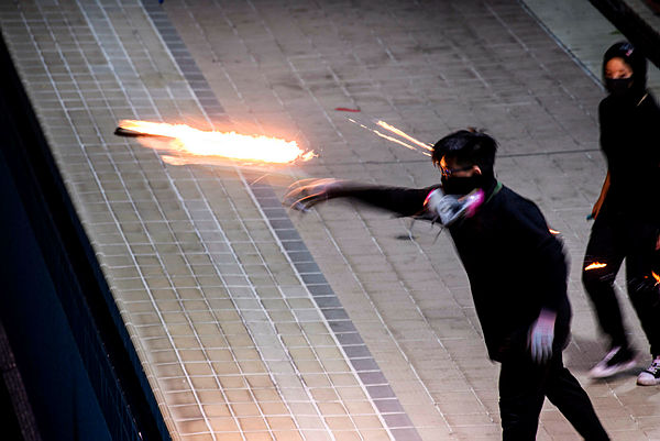In this picture taken on Nov 14 2019, a protester practices throwing a molotov cocktail into an emptied 50-metre Olympic-size swimming pool at the Hong Kong Polytechnic University in Hung Hom, Hong Kong — AFP
