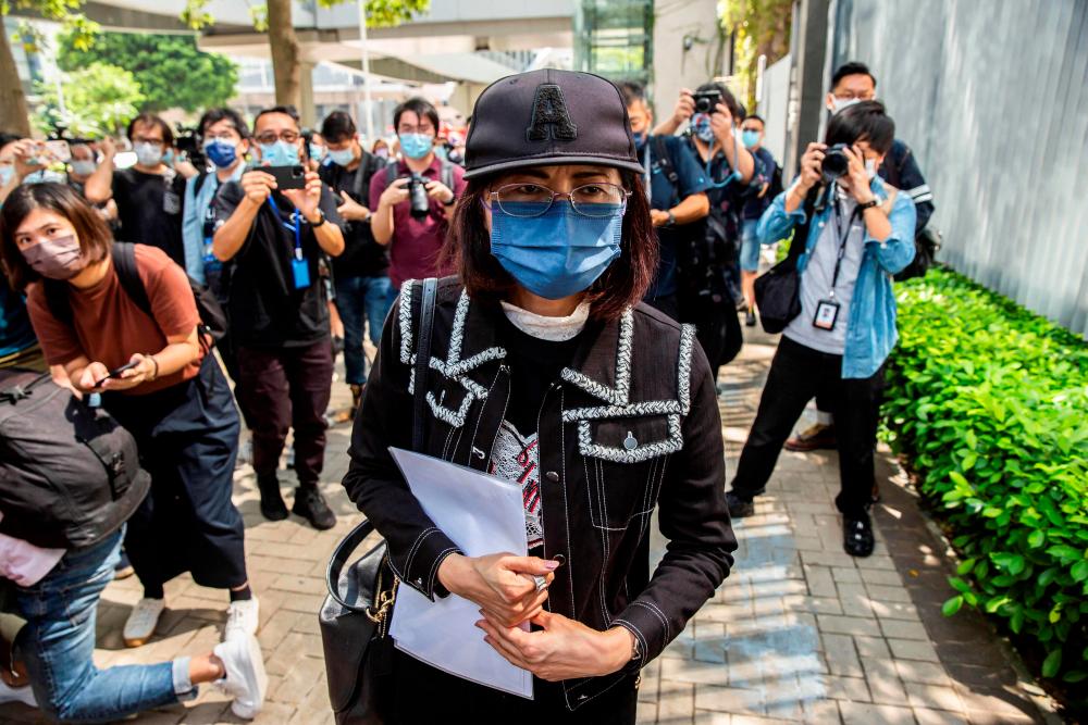 The mother of Poon Hiu-wing (C), a 19-year-old woman who was murdered by her boyfriend during a visit to Taiwan in 2018, leaves after speaking to the media outside government headquarters in Hong Kong on October 20, 2021. AFPpix
