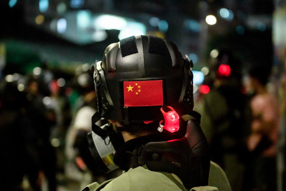 A Chinese flag is displayed on the back of the helmet of a riot police officer during a pro-democracy demonstrator in Yuen Long district of Hong Kong on Oct 21, 2019. — AFP