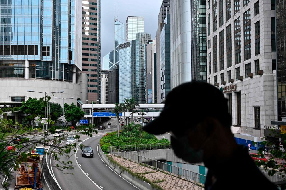 A man wearing a face mask walks in the Central district of Hong Kong on July 9, 2020, as the city experiences new local outbreaks of the Covid-19 coronavirus. - AFP