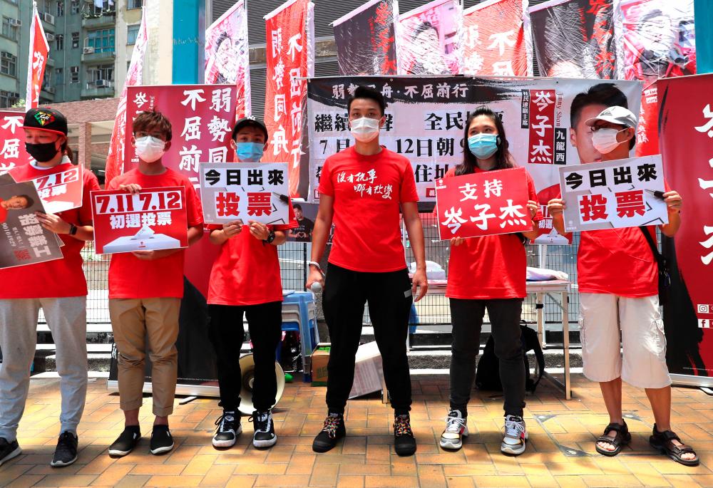 Jimmy Sham (C), a candidate of Kowloon West constituency, campaigns during a primary election in Hong Kong on July 11, 2020. Voters were casting their ballots on July 11 in the primary to select the pro-democracy opposition candidates for election to the city's legislative council in September. — AFP