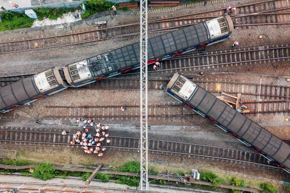 This aerial picture shows rescue workers standing on a railway track near a passenger train, after it derailed during rush hour outside Hung Hom station on the Kowloon side of Hong Kong on September 17, 2019. — AFP