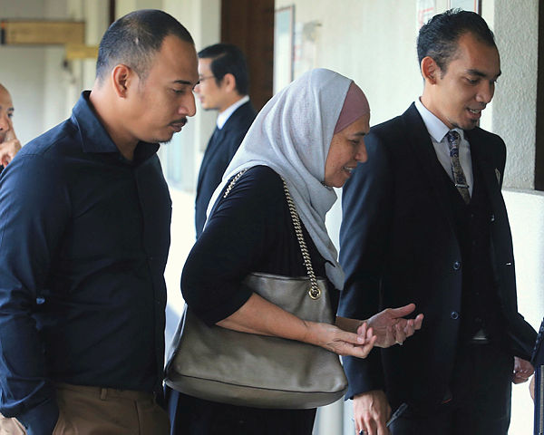 Former SSM CEO Datuk Zahrah Abd Wahab Fenner (C) and her son Abdulazeez Wan Ruslan (L) enter the sessions court at the Kuala Lumpur Court Complex today. — BBXpress