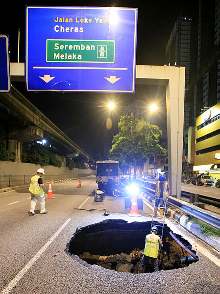 Filepix taken on Nov 25 shows workers examining a sinkhole at Jalan Loke Yew. — BBXpress