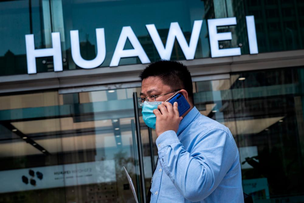 A man walks past a shop for Huawei in Beijing, China. – AFPPIX