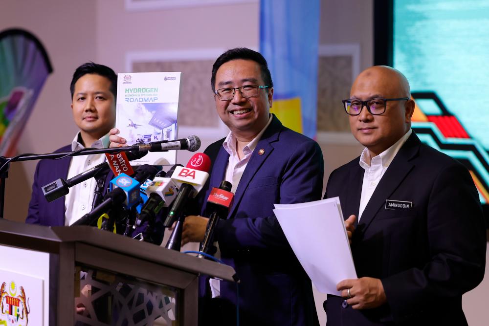 Chang holding up a copy of the Hydrogen Economy &amp; Technology Road Map tabled at the National Science Council’s meeting today. – Bernamapic