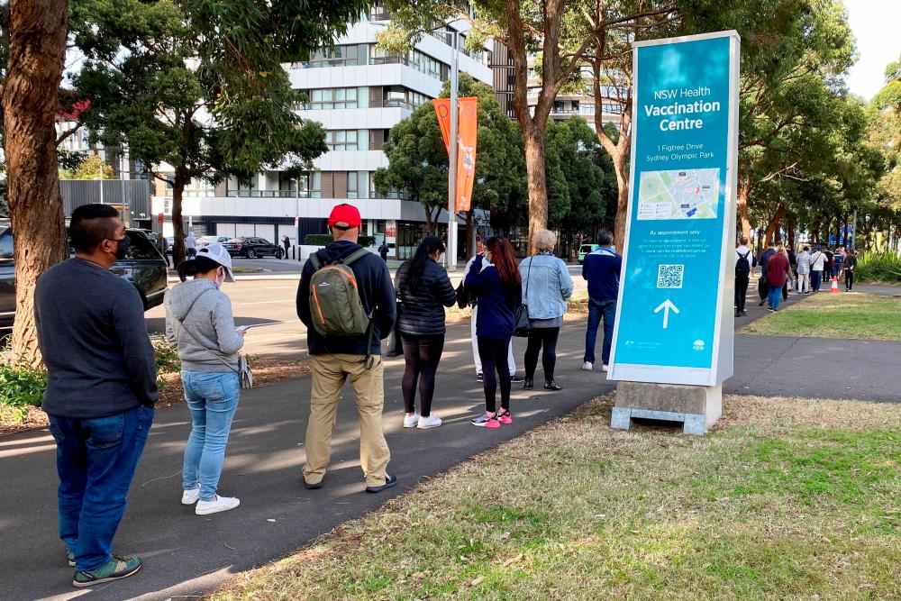 People wait in line outside a coronavirus disease (Covid-19) vaccination centre at Sydney Olympic Park in Sydney, Australia, June 23, 2021. -Reuters