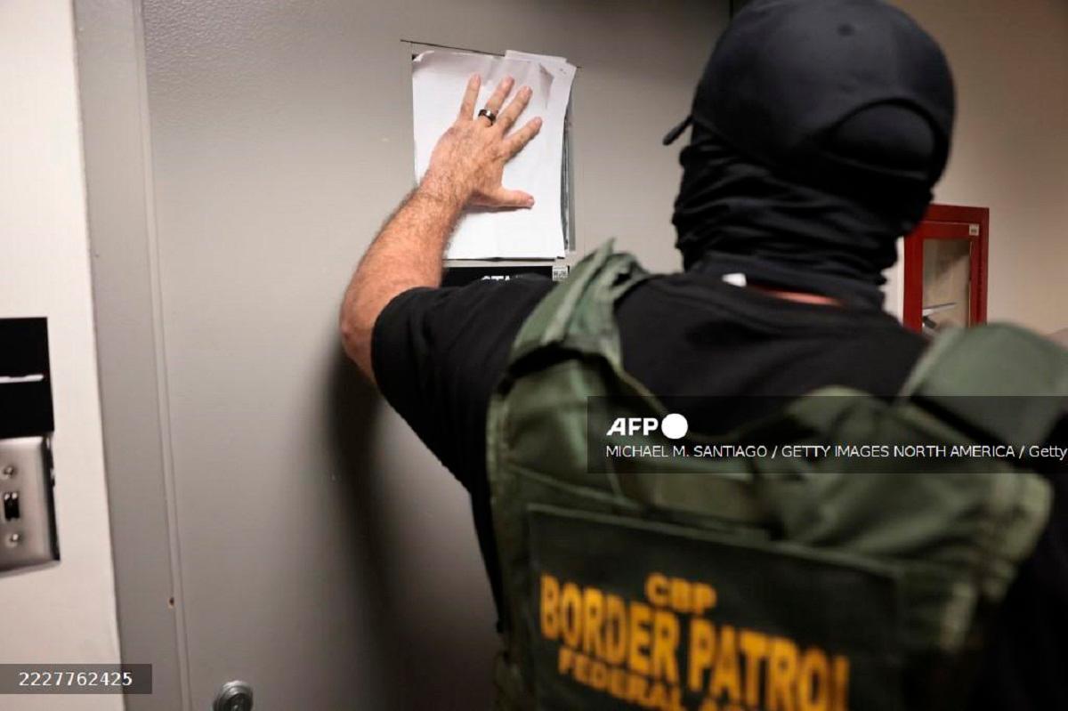 A federal agent blocks a window where detainees are being questioned outside of immigration court at the Jacob K. Javitz Federal Building on July 30, 2025 in New York City. - Michael M. Santiago / GETTY IMAGES NORTH AMERICA / Getty Images via AFP