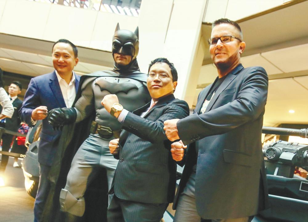 At the launch of Batman’s 80th-anniversary celebration ... Batman striking a pose with (from left) Tann, Lim and Rudge. – Amirul Syafiq Mohd Din/theSUN