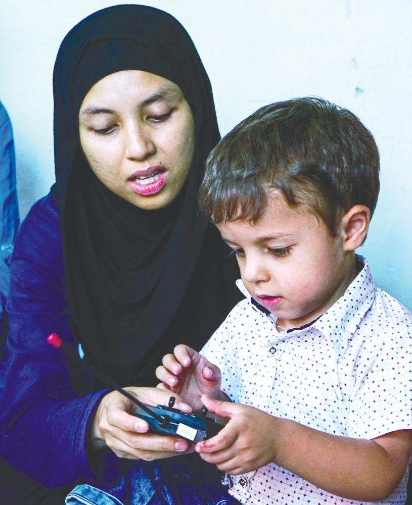 $!Shazrina teaching a Syrian boy how to work a remote control toy. – Courtesy of Cinta Syria Malaysia