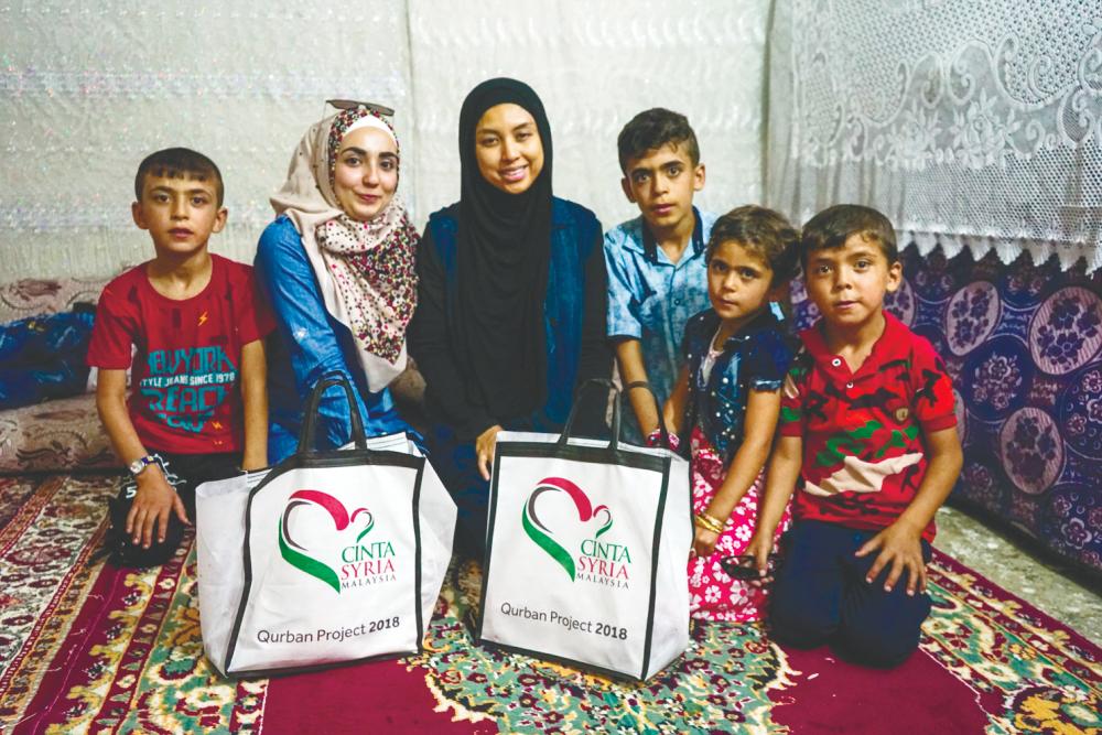 $!Shazrina distributing meat and aid during the Qurban Project 2018. – Courtesy of Cinta Syria Malaysia
