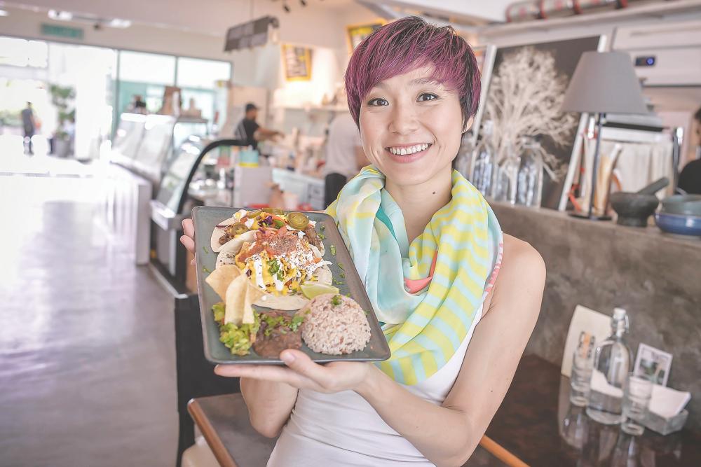 Goh holds up a plate of delicious Vegan food from Sala. –ADIB RAWI /THESUN