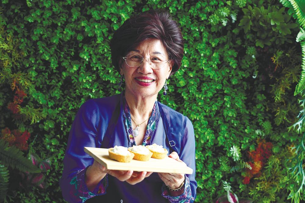 Tan showing off her special pumpkin cheesy tart at the event. – NORMAN HIU/ THESUN