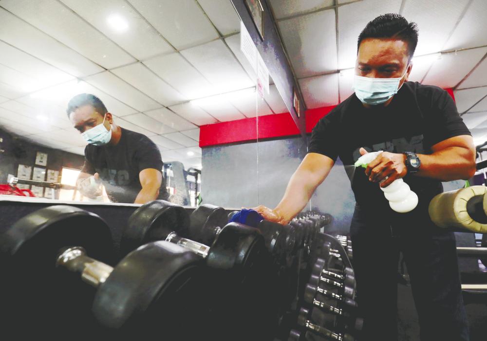 $!SAFE TO USE ... A staff disinfecting equipment at a gym in Butterworth yesterday after such establisments were allowed to operate during the movement control order under strict compliance to standard operating procedures. – MASRY CHE ANI/THESUN