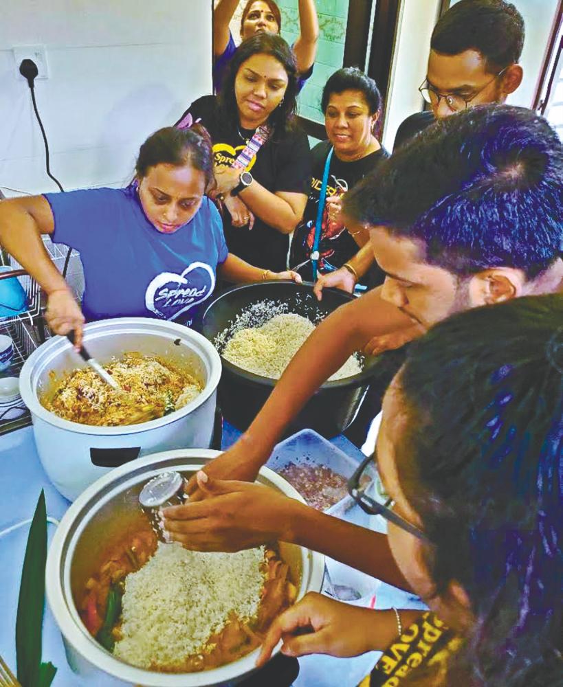 Megalah (left) and volunteers cooking for senior citizens. – Sunpix