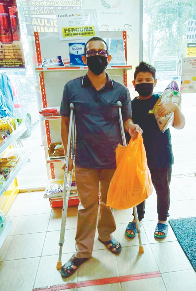 Recipients collecting free essential food at MyKampung FreshMart yesterday. – ASYRAF RASID/THESUN