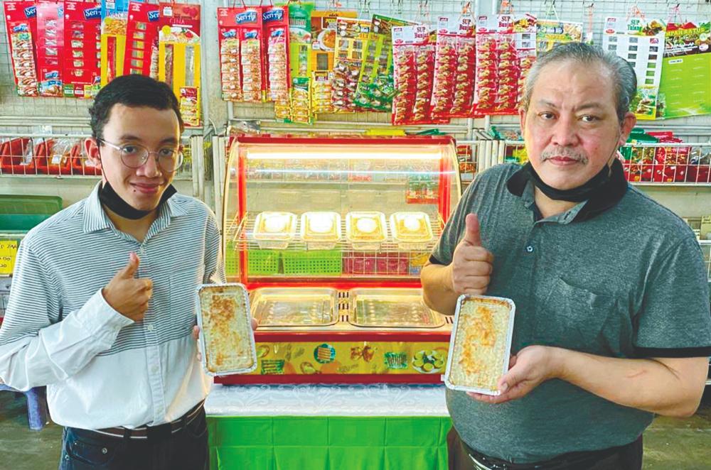 Hilmi and his father, Halim Borhan, with their homemade lasagne. – SUNPIX