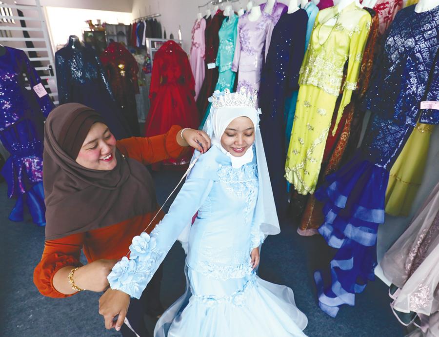 $!BACK IN BUSINESS ... Bridal shop owner Noryusmiza Yusop taking measurements of a customer at her boutique in Bukit Mertajam, Penang yesterday. – MASRY CHE ANI/THESUN