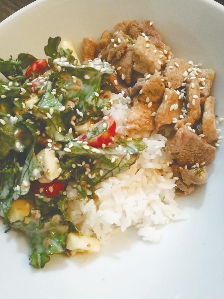 Kale salad with garlic butter pork in rice bowl