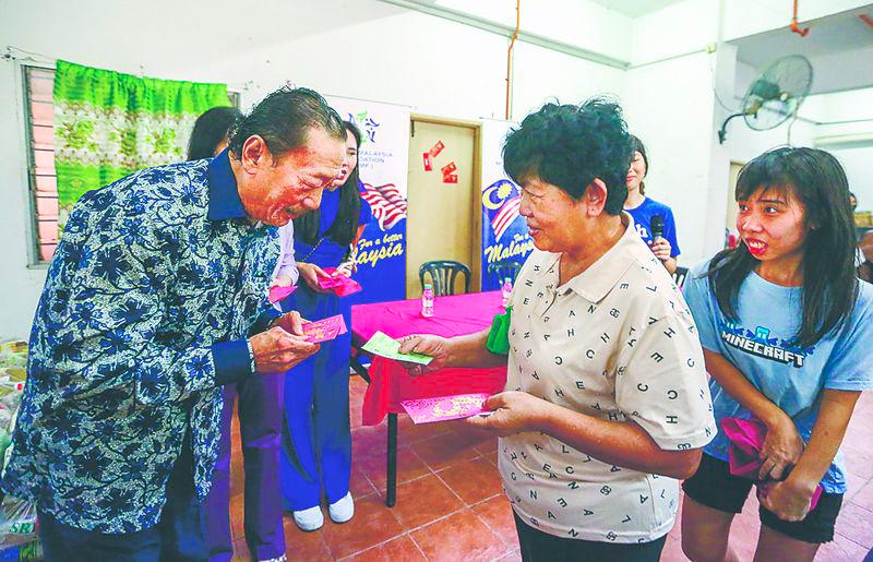 Tan presenting ang pow to PRR residents at the event. – Adam Amir Hamzah/THESUN