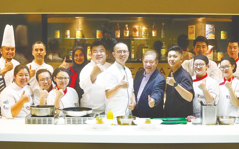 Chef Laurence Tai (centre) flanked by Chef Gary Chang (left) and Tunku Iskandar Tunku Abdullah with the culinary students. – MASRY CHE ANI/THE SUN.